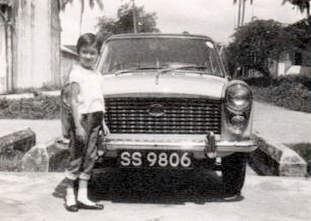 About 1960, many British Army, Navy and Air Force personnel served in Singapore and it was a period of very heavy registrations, as most purchased a car there or duty-free at home, to take out. This Austin A40 Farina belonged to a Wing-Commander, whose daughter June, modelling here, now dwells in Ottery St, Mary and makes jam for the W.I. Brumby archive.